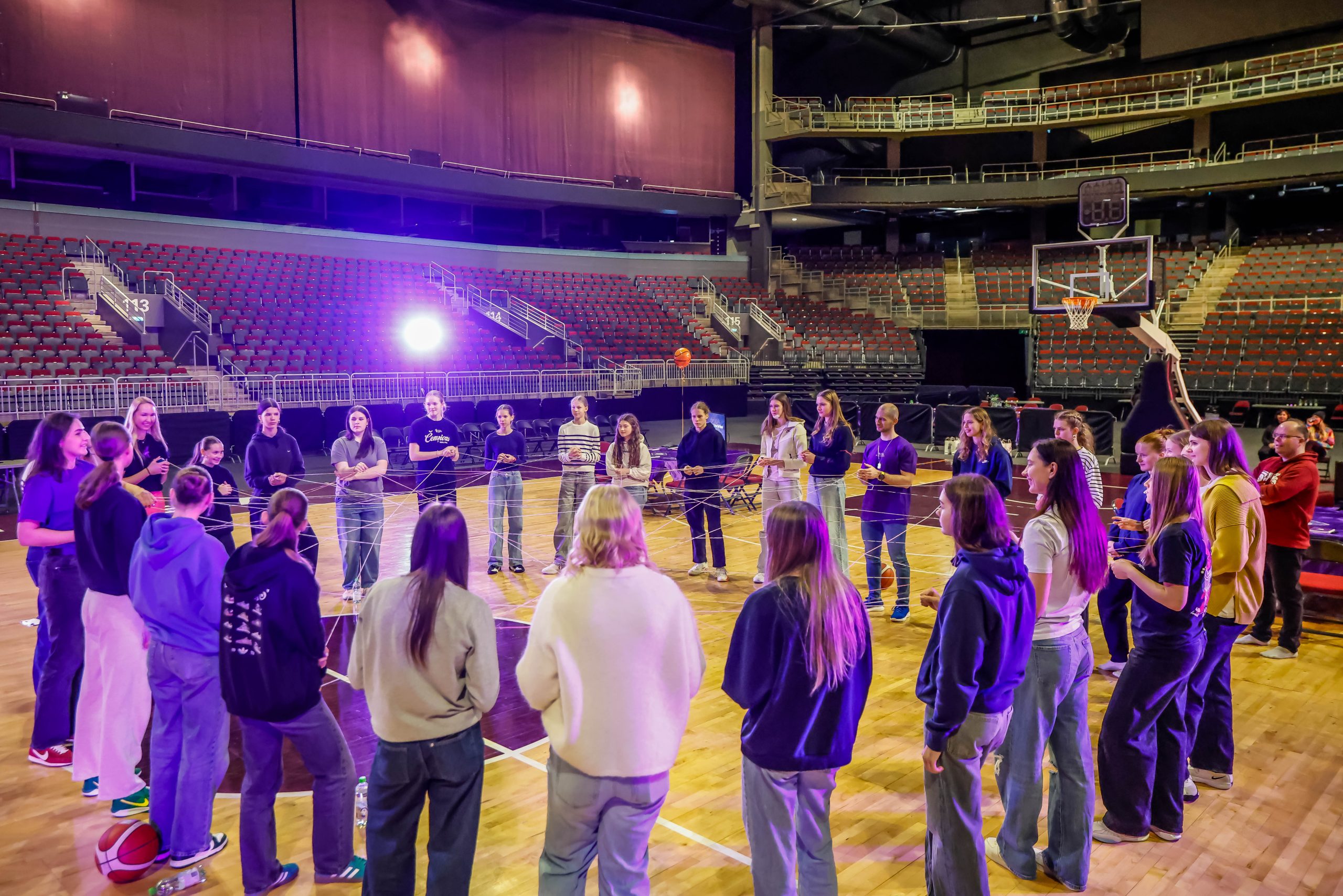 HerTake players gathered on a basketball court